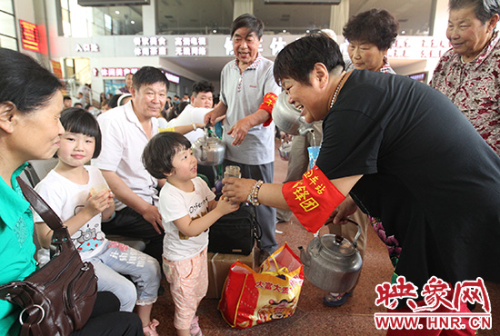 老年雷鋒團”志愿者在候車廳為旅客送水。