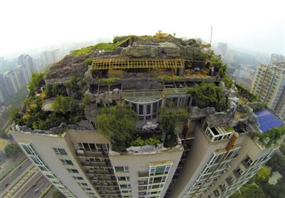 　　昨日，身穿橘黃色馬甲的工作人員在人濟(jì)山莊樓頂拆除違章建筑。新京報(bào)記者 吳江 攝