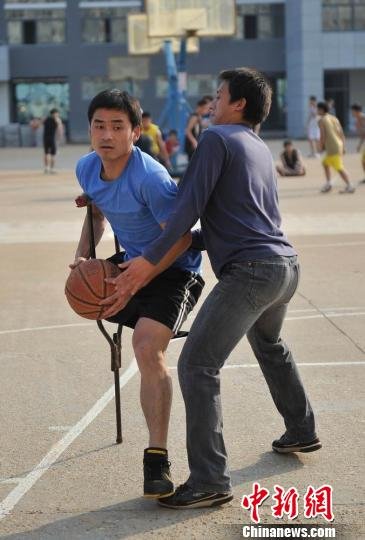 圖為拄著拐杖的瞿詩濤和同學(xué)搶球。劉占昆攝