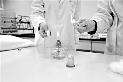 實(shí)驗(yàn)人員操作的燃燒檢測法中，真蠶絲離開火焰就熄滅(左)。