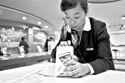 11月6日，北京移動(dòng)西直門(mén)營(yíng)業(yè)廳的工作人員在為顧客購(gòu)買(mǎi)的4G手機(jī)登記。新華社發(fā)