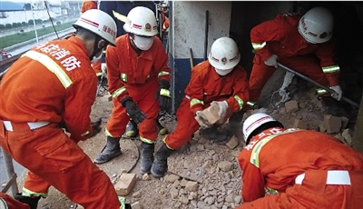 消防人員在清理熔鹽爐倒塌的廢墟。