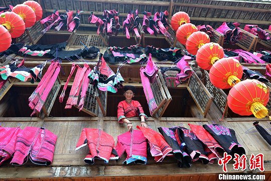 圖為紅瑤姑娘把紅衣晾曬出來(lái)。中新社發(fā) 韋吉陽(yáng) 攝