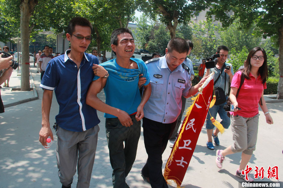 圖為獲救嬰兒父親情緒一度失控，當(dāng)?shù)鼐焦ぷ魅藛T對(duì)其進(jìn)行攙扶。張一辰 攝