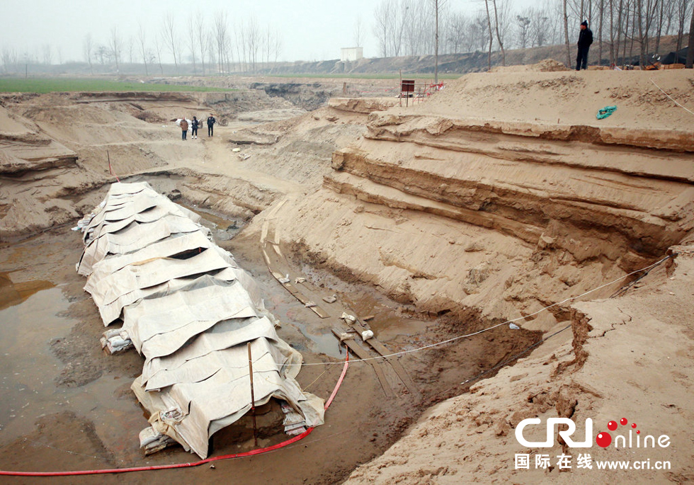 2014年1月6日，河南洛陽古沉船發(fā)掘現(xiàn)場，近日有雨雪天，考古人員給古沉船披上一層“雨衣”。