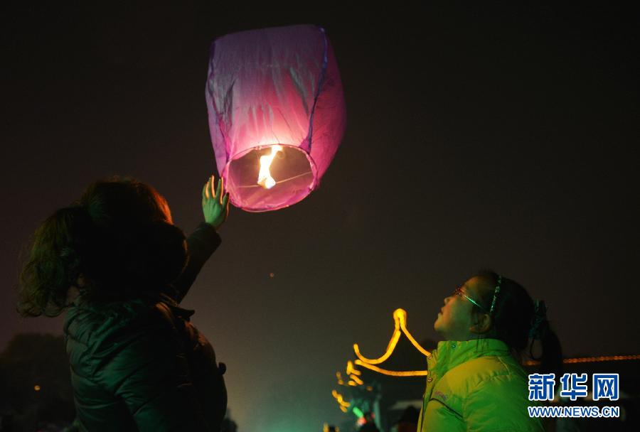 　1月30日，游客在江蘇省鎮(zhèn)江市金山公園門口放飛孔明燈。
