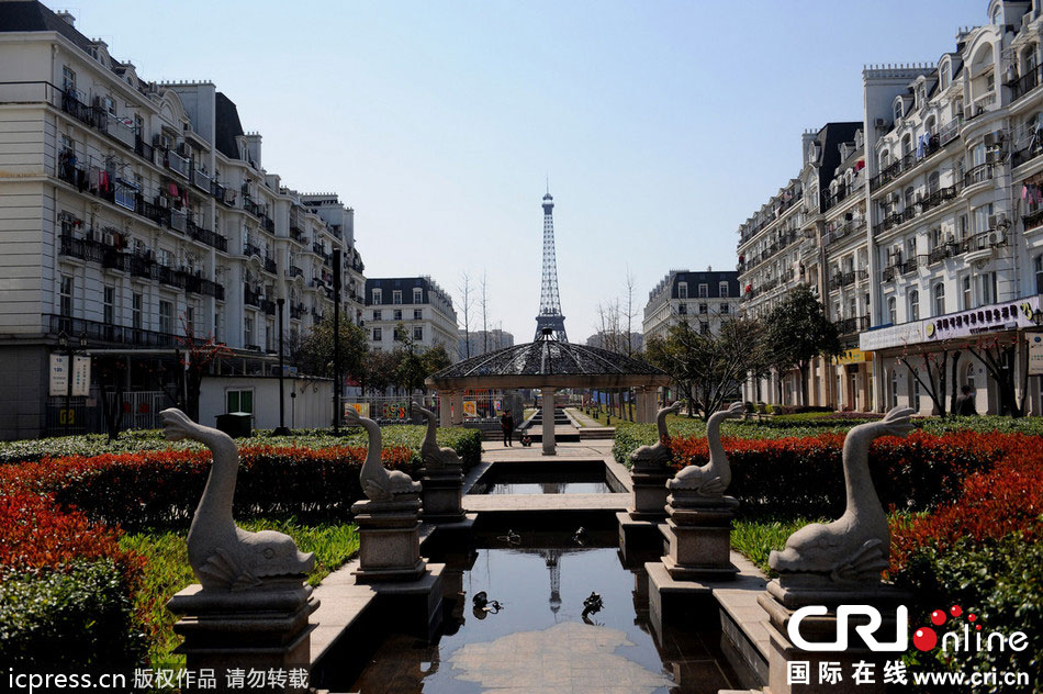 　2014年3月21日，杭州天都城，農(nóng)民在山寨埃菲爾鐵塔下耕作。圖片來源：東方IC