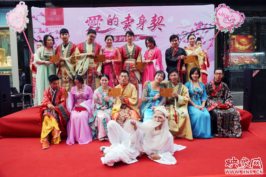 現(xiàn)場(chǎng)8對(duì)兒年輕男女舉起“賣(mài)身契”集體拍照。