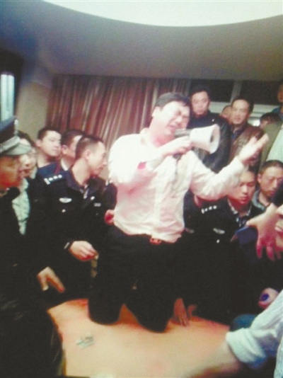 　4月19日，泰州市濱江工業(yè)園區(qū)管委會(huì)招待中心，一男子跪在酒桌上喊話求饒。李根 攝