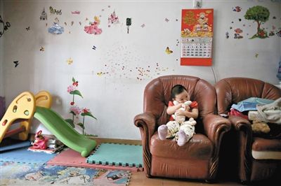 6月14日，未婚媽媽于軍的家里。女兒悅悅抱著兔子玩偶，在聽媽媽手機(jī)上的兒歌，這個4歲女孩喜歡兔子。