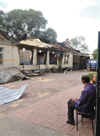 7月27日，海倫聯(lián)合敬老院內(nèi)，幾名老人看著對面被燒毀的特護(hù)病房。新京報(bào)記者 涂重航 攝