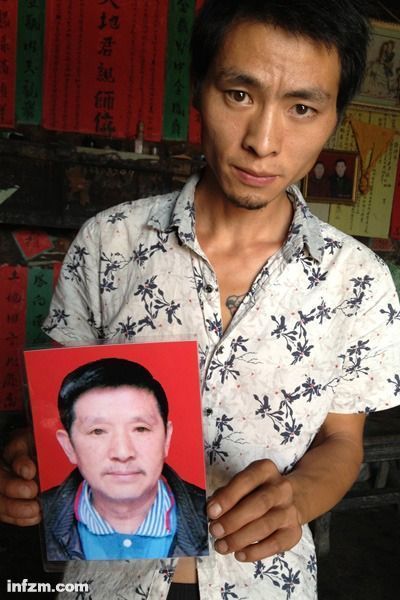 程興貴的兒子程正鵬拿著父親的遺照。程興貴自殺后，政府補償程家6000多塊錢，并終于認定了程興貴的代課教齡。 (南方周末記者雷磊/圖)