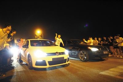 8月24日晚，東壩中街飆車現(xiàn)場，兩輛車并排等待出發(fā)指令，旁邊許多愛好者前來觀看比賽。新京報(bào)記者