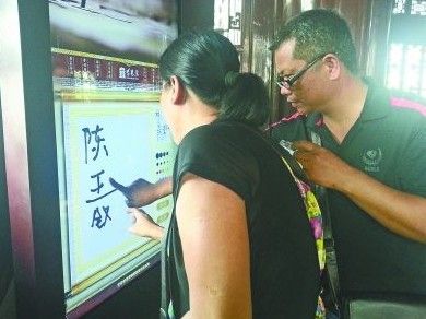 　圖為一對游客夫妻在“涂鴉”。