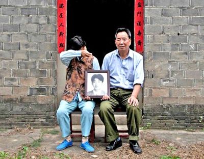 江蘇鎮(zhèn)江，老劉夫婦捧著獨(dú)生子的遺像在老家前留影南方都市報供圖L