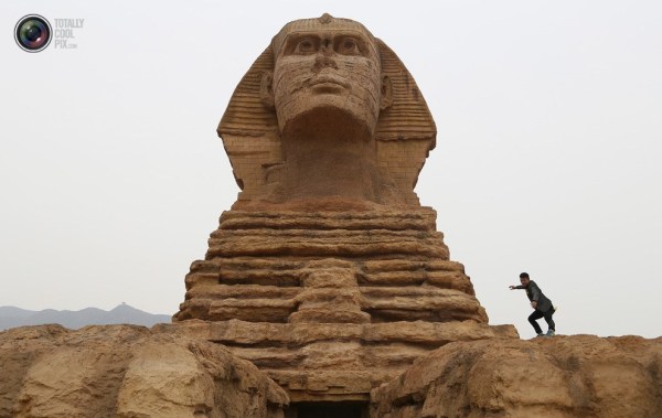 石家莊郊外，一名男子與山寨版獅身人面像合影留念。