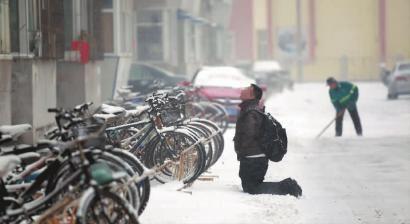 小伙子跪在樓前，一直抬頭看著樓上。 孫立國/攝