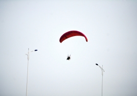 10月25日下午，動力傘從一對路燈上空飛過