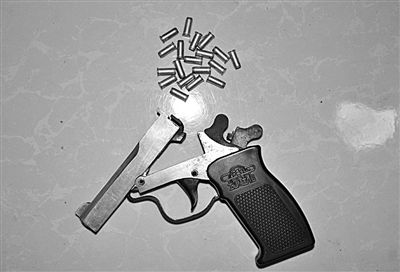 警方從搶劫嫌疑人處起獲的贓款和發(fā)令槍、子彈。警方供圖