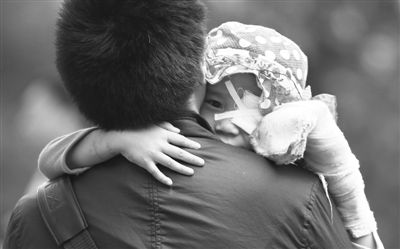 昨日，北京同仁醫(yī)院，被砍傷的彤彤趴在舅舅的肩上。他們剛剛掛完號(hào)，正準(zhǔn)備回旅館。新京報(bào)記者 尹亞飛 攝