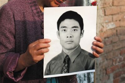 5月19日，朝陽北路，母親捧著張東文的遺像。新京報(bào)記者 侯少卿 攝