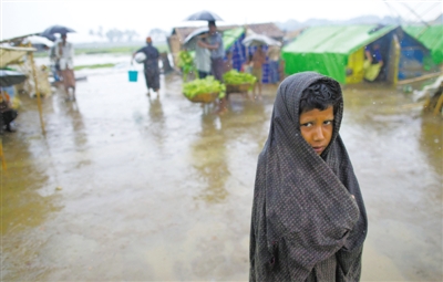 5月14日，緬甸若開(kāi)邦實(shí)兌難民營(yíng)，羅興亞族難民在雨中行走。熱帶風(fēng)暴“馬哈森”即將登陸緬甸，這里的難民開(kāi)始乘船撤離。
