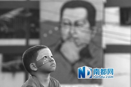 3月5日，一名委內(nèi)瑞拉兒童仰望天空，他身后是查韋斯的陵墓。