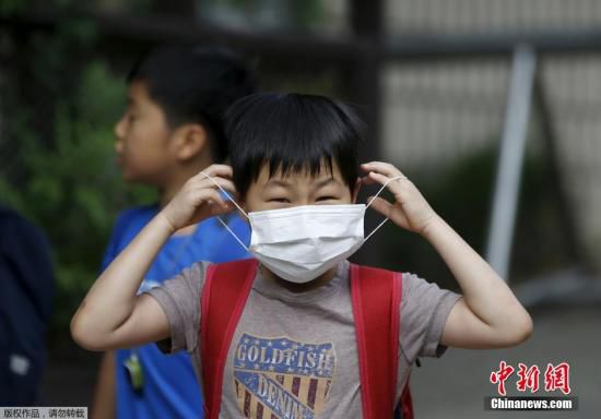 圖為當(dāng)?shù)貢r間2015年6月8日，韓國未停課的學(xué)校，學(xué)生課前戴口罩測體溫。