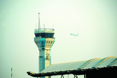 一架飛機飛過機場塔樓 一架飛機飛過機場塔樓