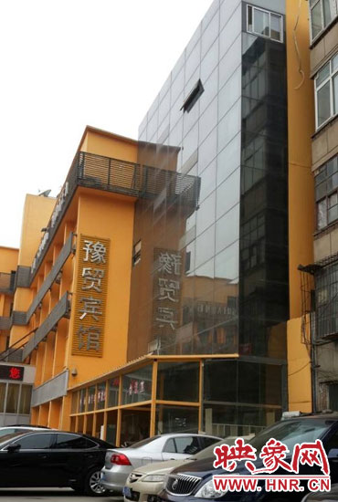 該酒店為加蓋樓層統(tǒng)一安裝上黑色玻璃，從前面看不出加蓋的痕跡