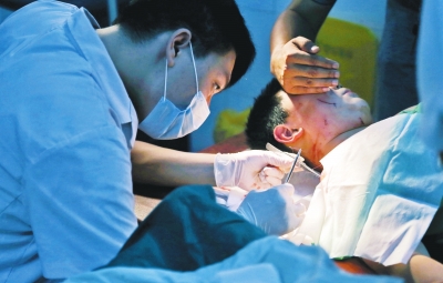 孩子身上有7道傷痕，其中兩道需要縫合，其他的均為擦傷，醫(yī)生正對他施治。