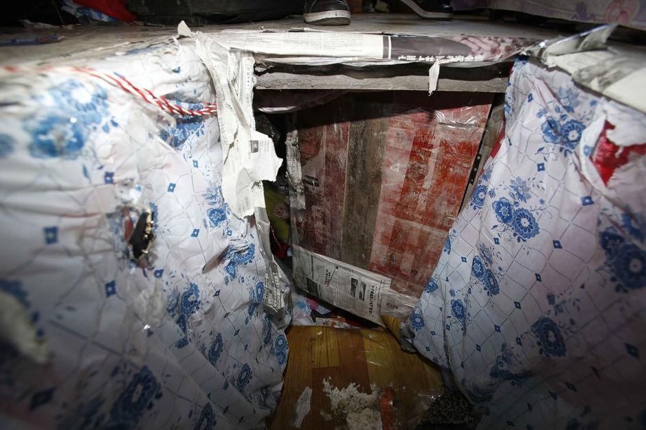 陳小龍在出租屋外，自行又圍起一堵圍墻，安裝了一個門。圍墻上都是豎起的鐵釘，外面堆著土，鄰居猜是從地底挖出來的。洞口就在床邊，0.5米見方，深約1.5米。洞口表面一塊紙板掩蓋，打開紙板跳入洞底，是一扇小木門，木門外有插銷，可以從外面鎖上。