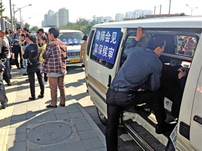 昨日，朝陽區(qū)看守所門前有人排隊。大門外還停有多輛寫有“律師會見”字樣的車。