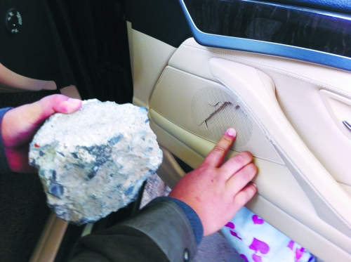 “飛”進(jìn)寶馬車內(nèi)的大石塊,將寶馬車的車門內(nèi)飾板砸爛。