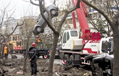 輸油管道爆炸后，搶修人員將被炸毀的車輛運出現(xiàn)場。