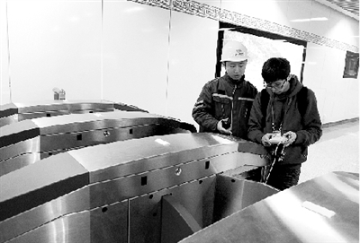 昨天上午，體育中心站，工作人員正在對進出站閘機進行調(diào)試。