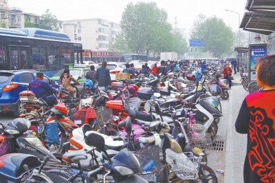 省人民醫(yī)院北門，路邊的公交站牌處停滿非機(jī)動(dòng)車，上、下客只能在快車道上。