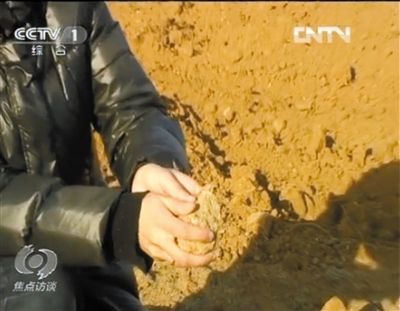 麻剛沙系麻剛石粉碎而成。記者找到一塊麻剛石，一捏就碎成粉末，硬度非常差。央視截圖