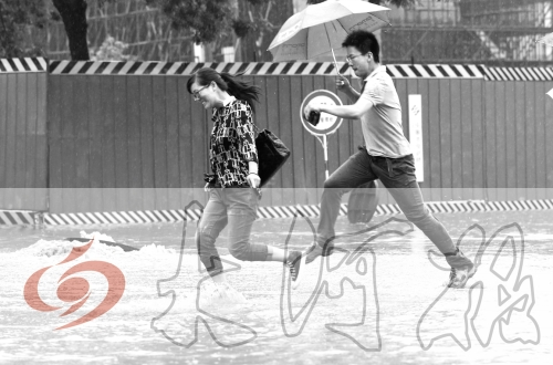 鄭州經(jīng)三路與北環(huán)交叉口處，積水較深，行人們不得不“練輕功”。 記者 白周峰 攝影