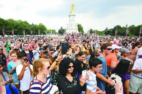 7月23日，在英國倫敦白金漢宮外，民眾們爭相閱讀“王室寶寶”出生的正式公告。