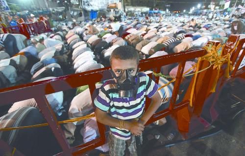 當(dāng)?shù)貢r(shí)間28日晚，在埃及開羅納賽爾城，一名小男孩頭戴防毒面具參加穆兄會(huì)的集會(huì)示威。