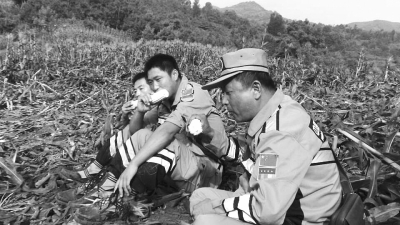 饑餓難忍，中國(guó)緊急救援河南基地的救援隊(duì)員在已毀的玉米地里撿拾生玉米吃。