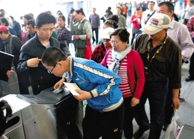 去年5月5日，14號(hào)線園博園站，乘客刷卡出地鐵。北京公交地鐵將實(shí)行計(jì)程票制，多乘坐多付費(fèi)。