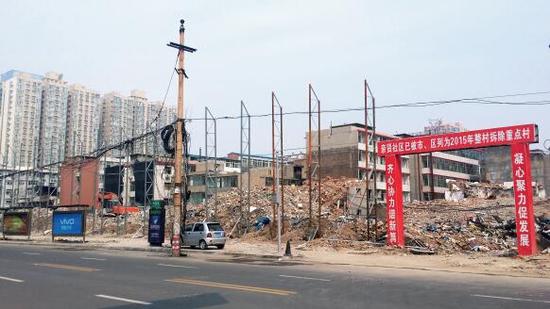 015年5月31日，在社區(qū)干部的帶頭拆遷下，親賢社區(qū)的“城中村改造”拉開帷幕。由于前期“清產核資”及補償標準等因素，拆遷改造工作推進并不順利。圖為位于體育西路東側集體所有的商鋪率先被拆遷完畢，用于遮擋的圍擋正在施工中。（拍攝：2015年9月16日）