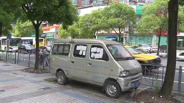 被棄置在人行道上的面包車(chē)。