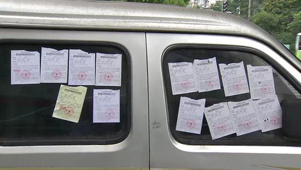 面包車(chē)上滿滿貼了14張罰單。