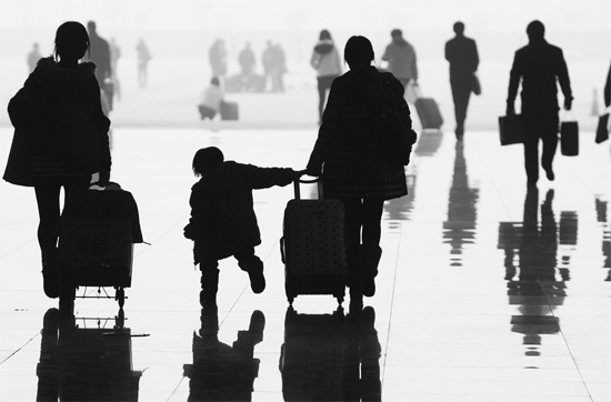 昨日，鄭州東站，一名孩子拉著媽媽和包裹快樂(lè)地奔走在春運(yùn)的途中