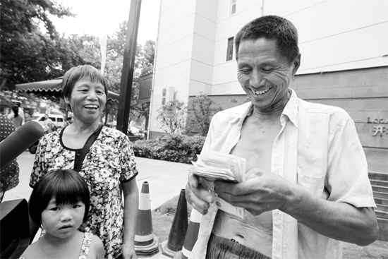 昨日，鄭州市明達(dá)路與豐慶路交叉口西300米路南，來自中牟的瓜農(nóng)拿到西瓜款，笑開顏東方今報記者袁曉強(qiáng)