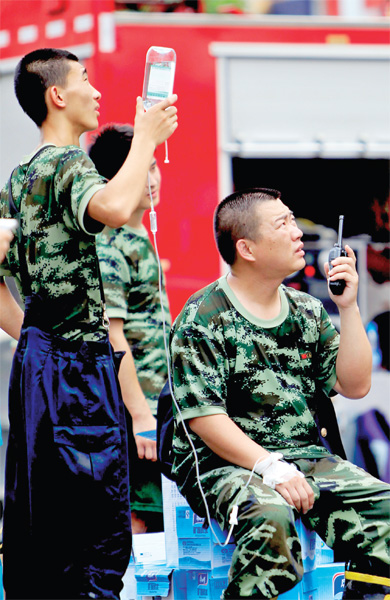 火場外，被消防戰(zhàn)士稱為“李大隊”的救援人員掛著吊瓶現(xiàn)場指揮