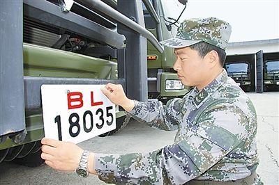 駐京某部上士高振超正在認(rèn)真更換新式軍車號牌。　　　本報記者　尹　航攝